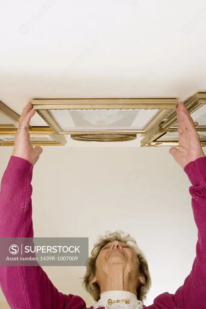 Woman adjusting picture frames