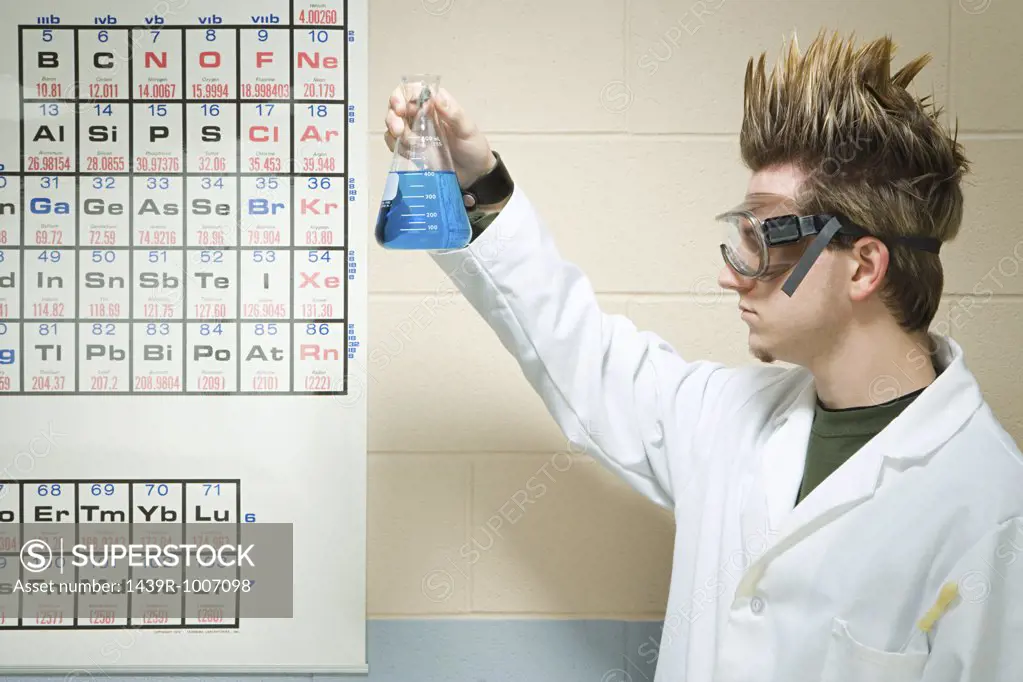 Male student holding up a chemical liquid