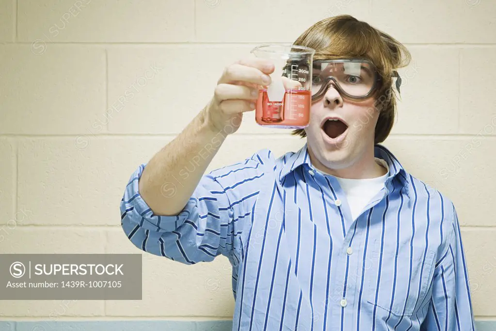 Male student holding flask of chemicals