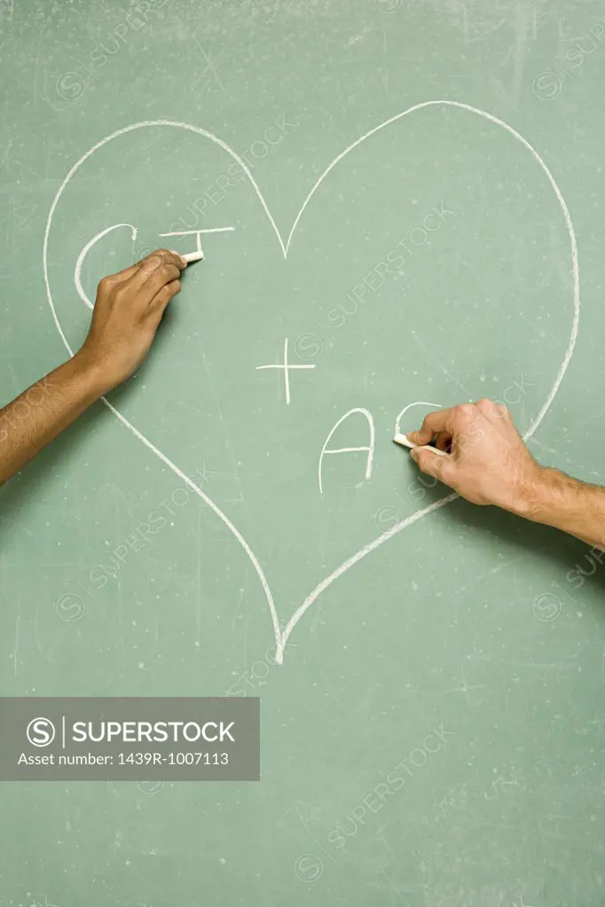 Two students drawing on blackboard