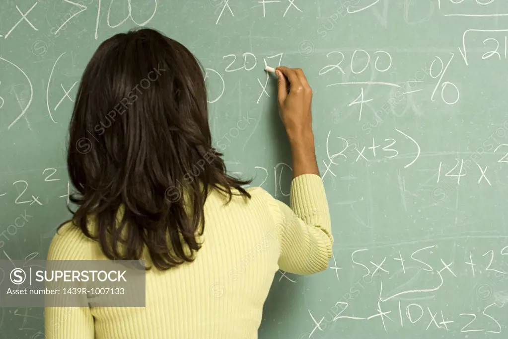 Female student writing on blackboard
