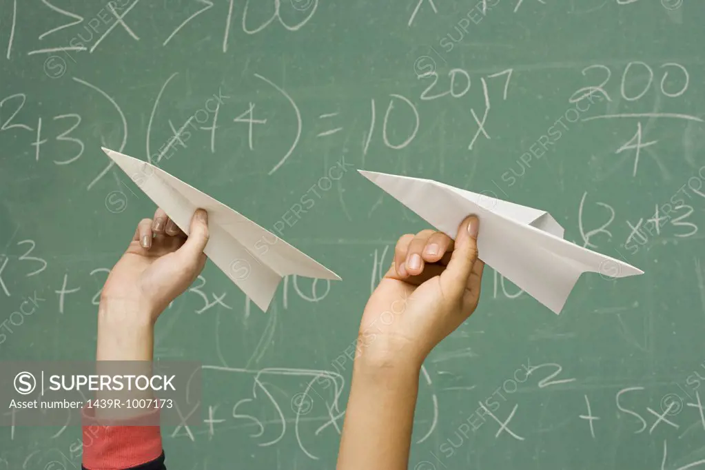 Two students about to throw paper aeroplanes