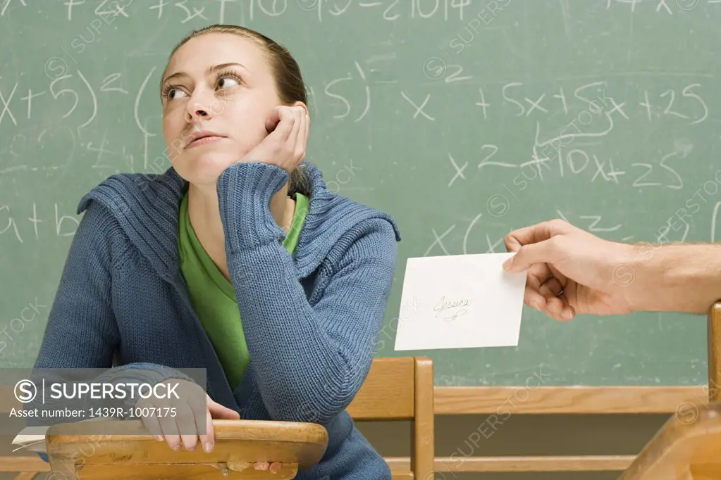 Boy passing girl a letter in class