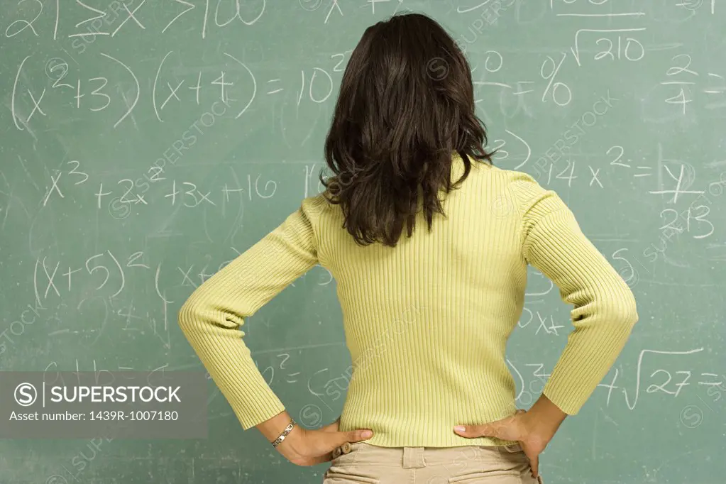 Female student stood in front of blackboard