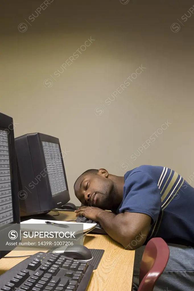 Male student sleeping at his computer