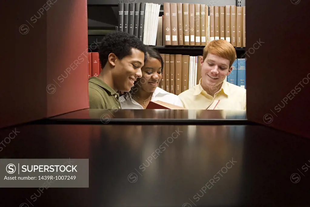 Three students reading in the library