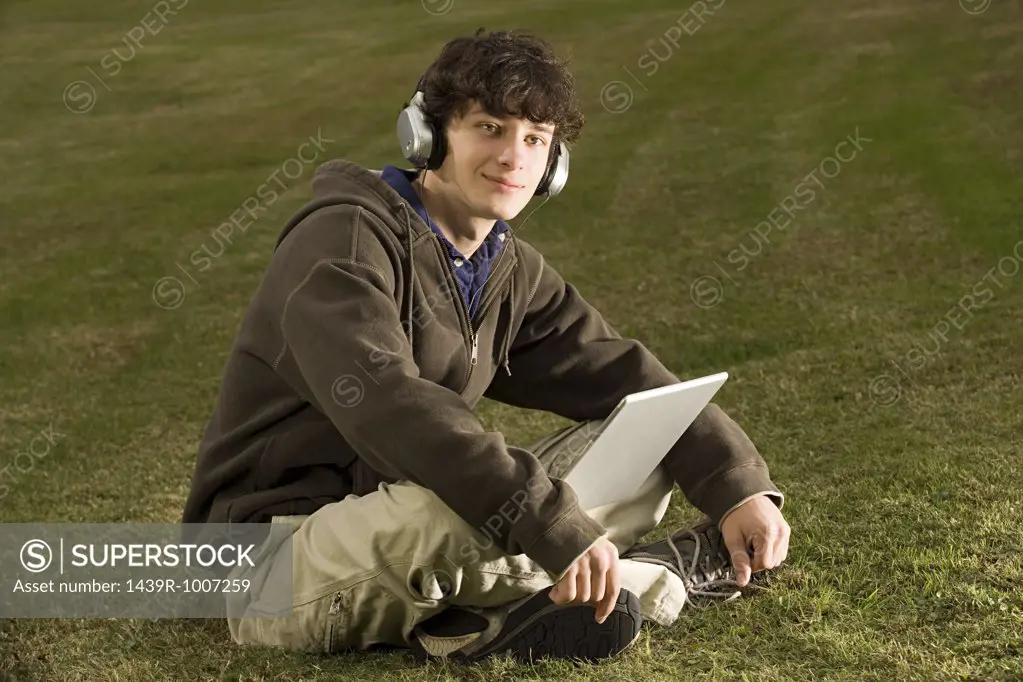 Male student using a laptop outdoors