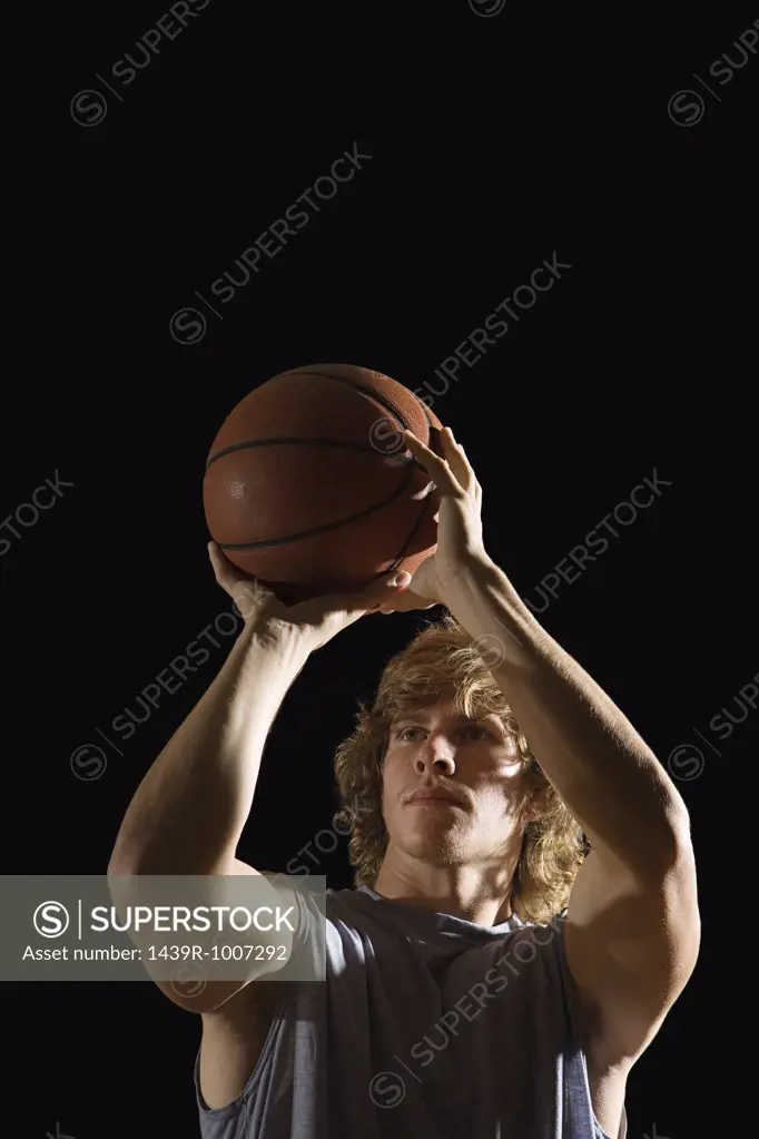 Young man aiming basketball