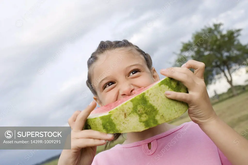 Girl eating a large slice of watermelon