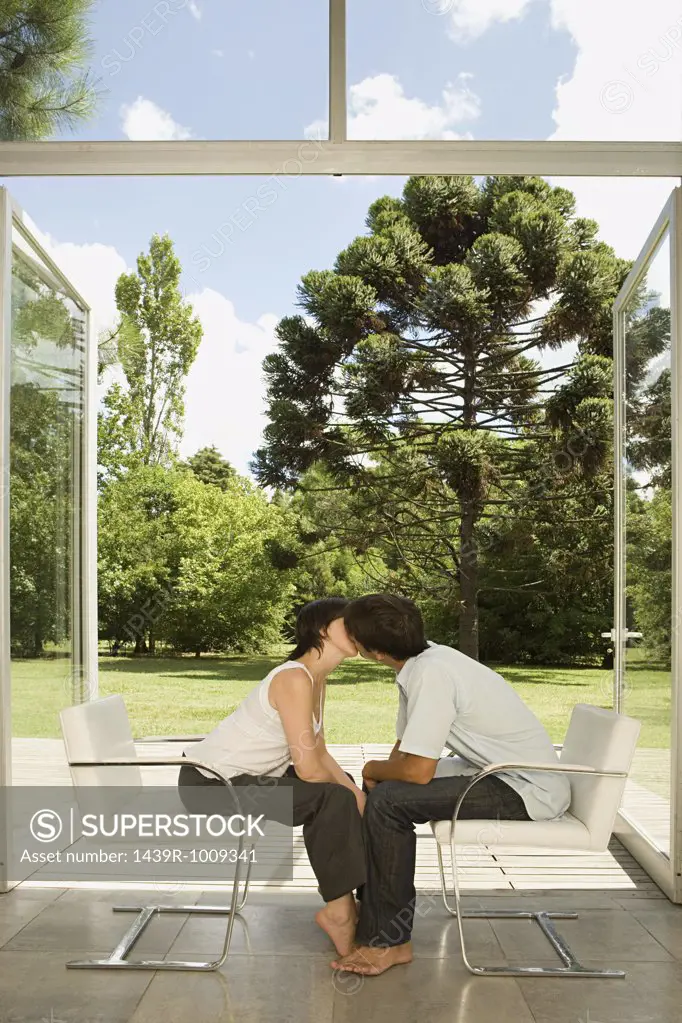 Couple sitting in chairs and kissing