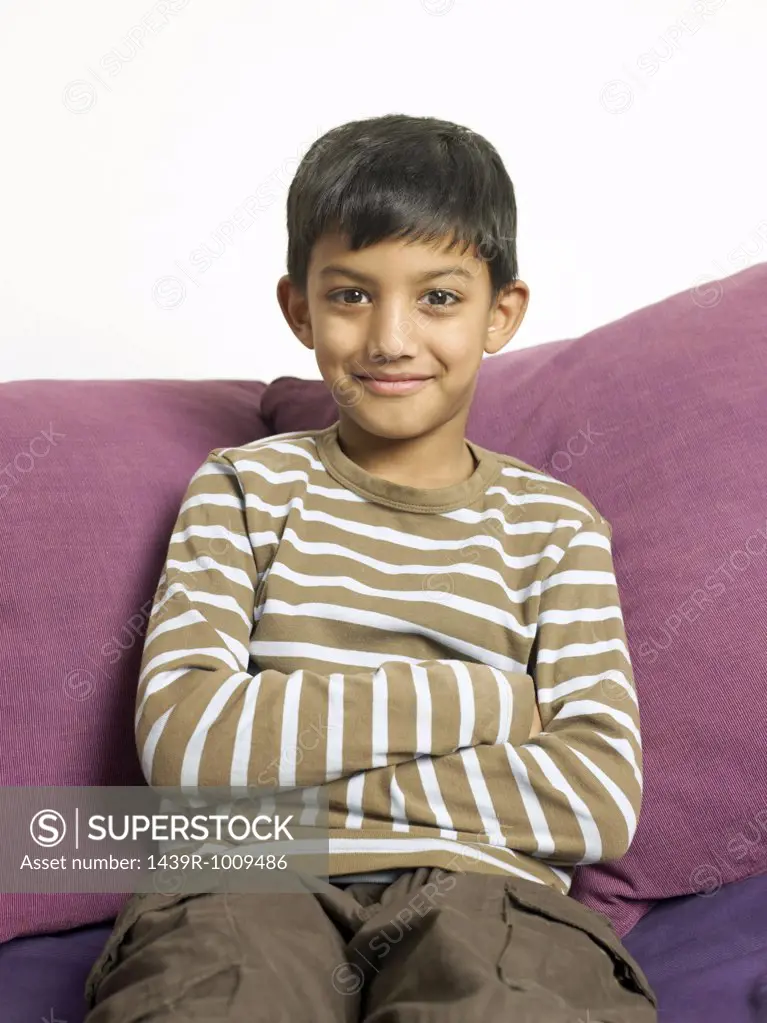 Smiling boy sitting on a sofa