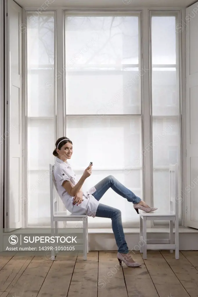 Woman sitting on chair with cell phone