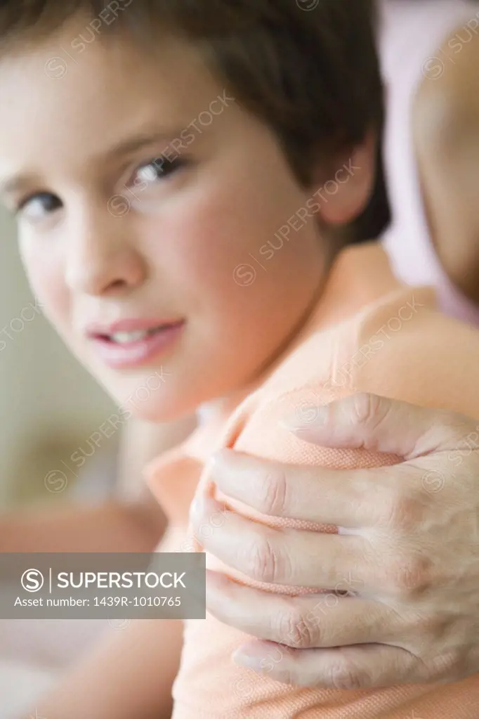 Boy with mother's hand on his shoulder