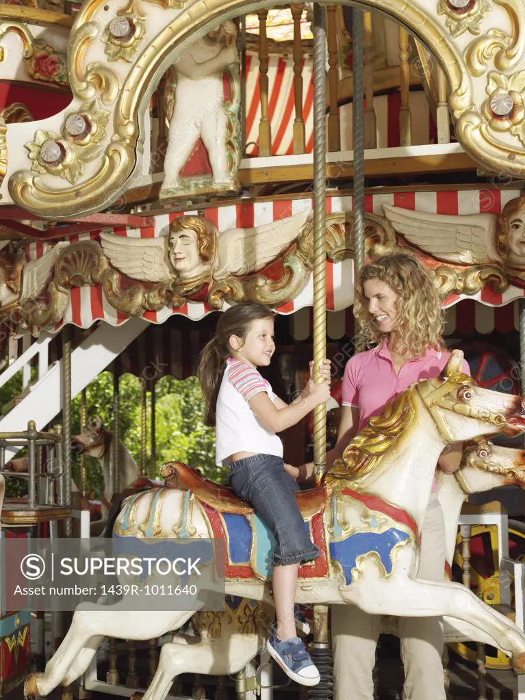 Mother and daughter on carousel