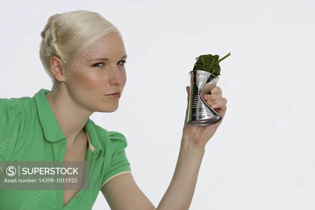 Young woman holding a can of spinach