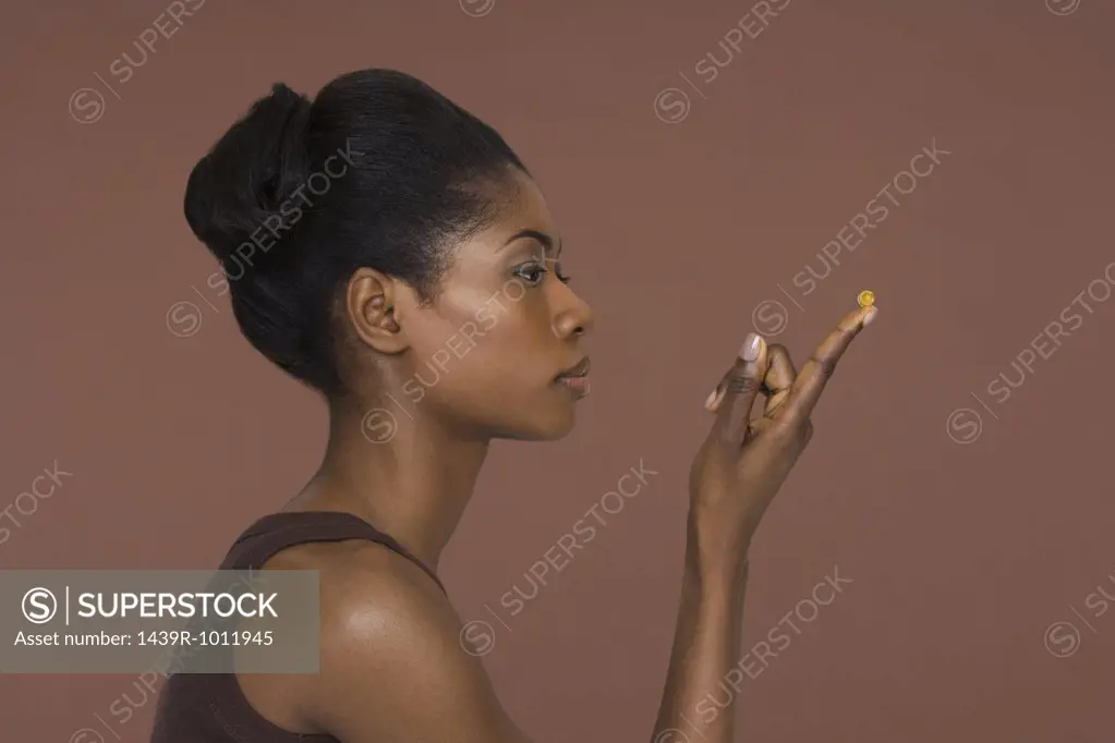 Young woman holding a capsule
