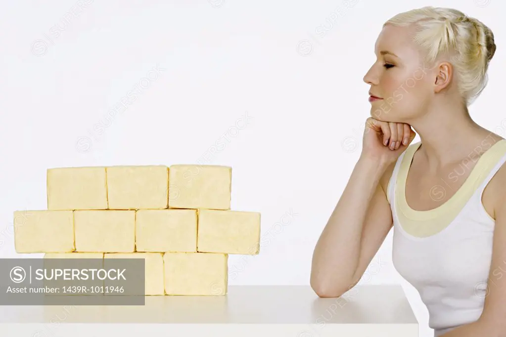 Young woman sat next to blocks of butter