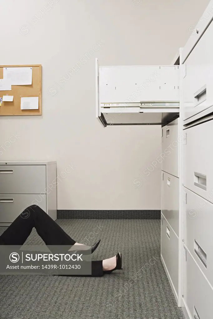Woman lying by filing cabinet