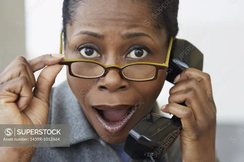 Shocked looking woman on the telephone