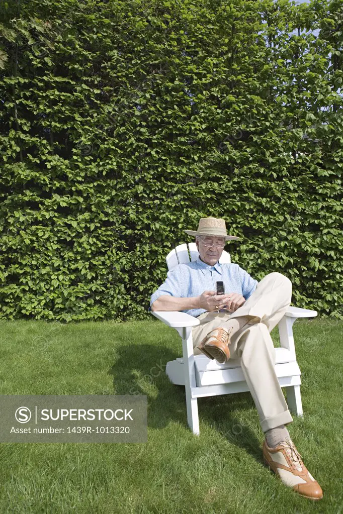 Senior man in garden with cellphone