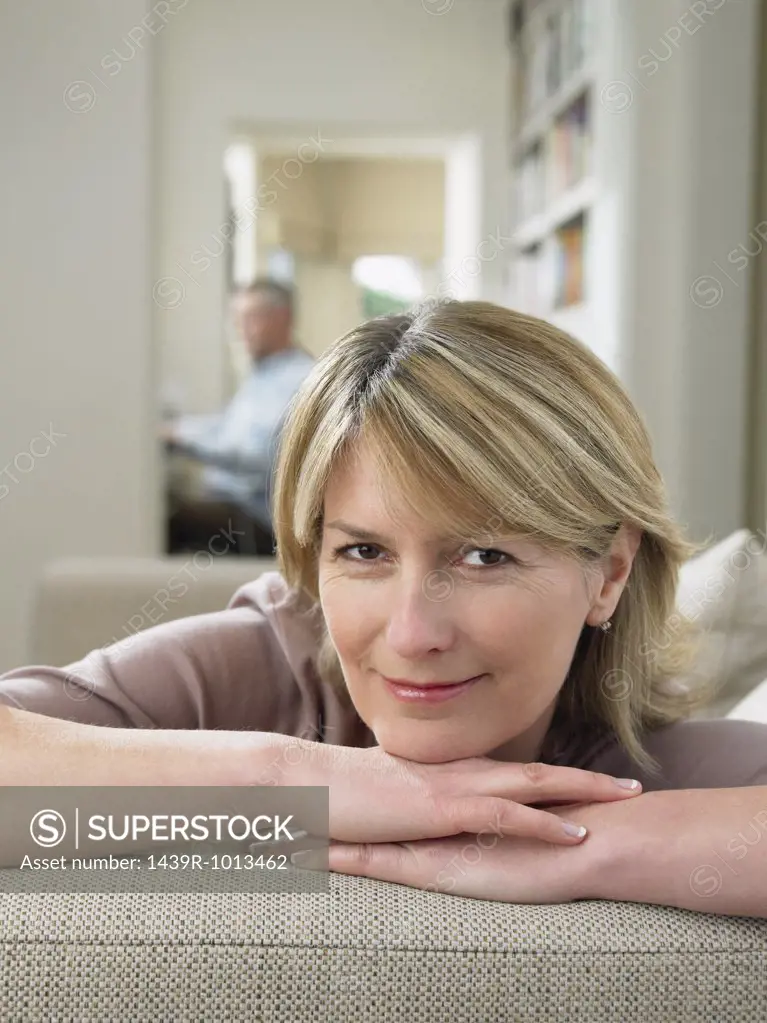 Smiling woman resting on sofa