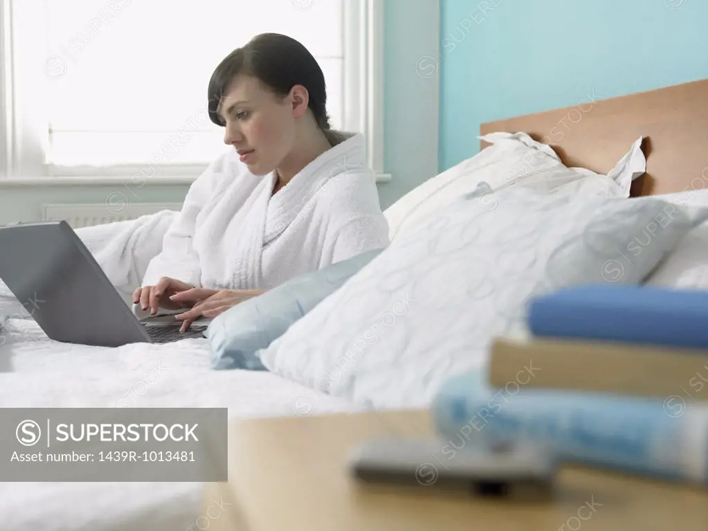 Woman using a laptop computer in bed