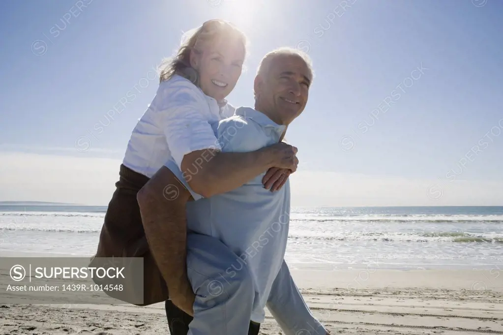 Senior man carrying woman on back