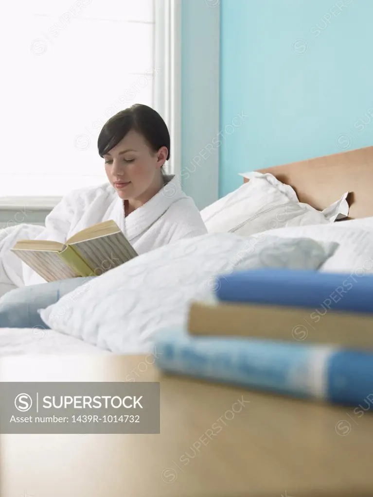 Young woman reading in bed