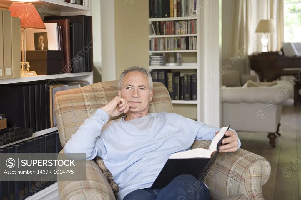 Man in an arm chair with book