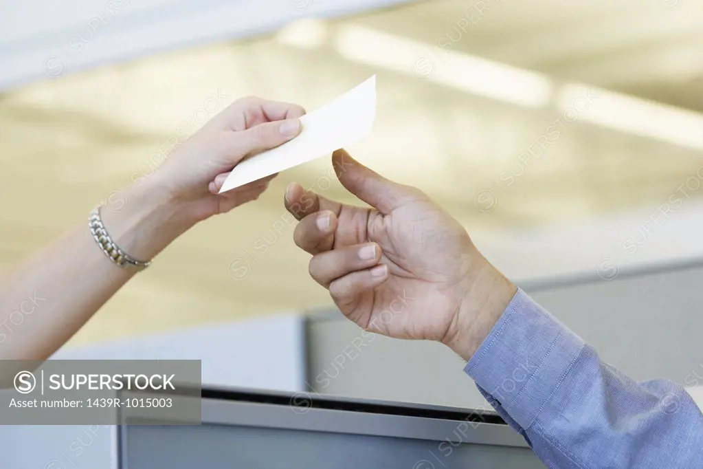Two colleagues passing a note