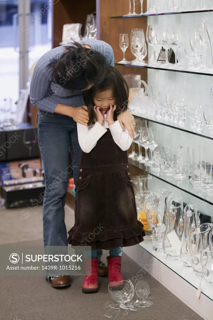 Mother comforting daughter over broken glass