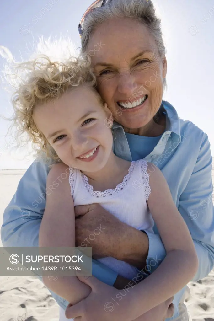 Grandmother and granddaughter posing on beach