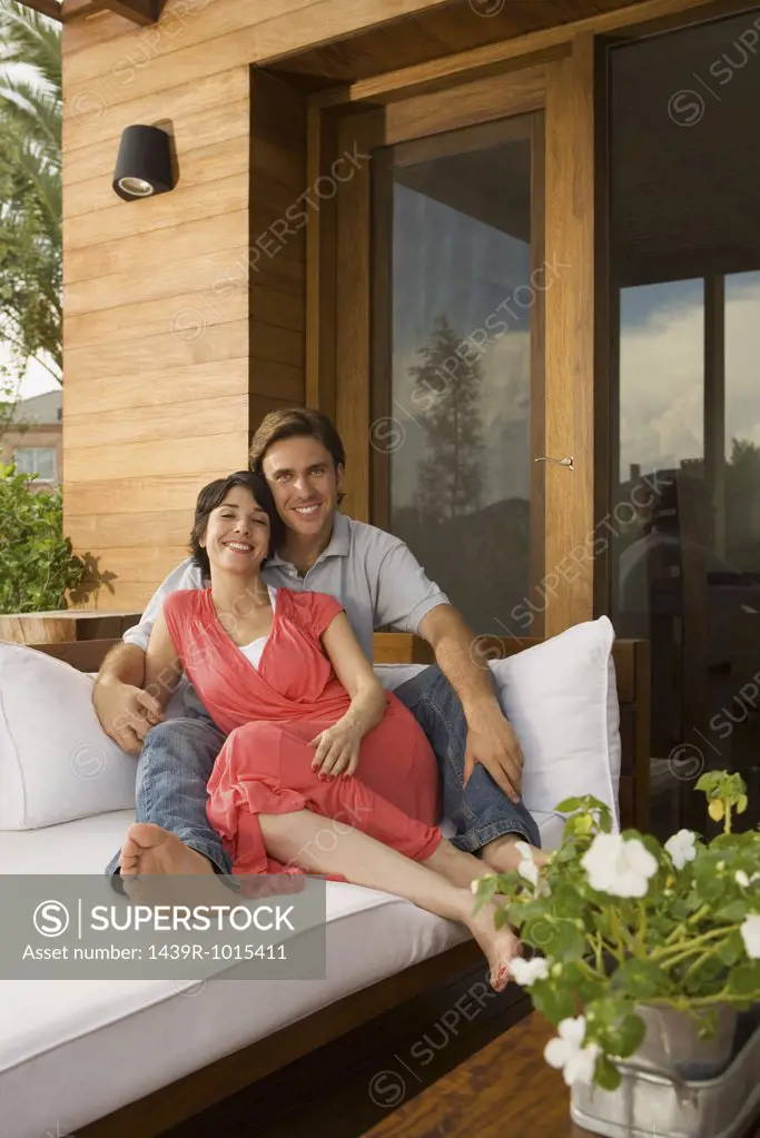 Couple relaxing on sofa outdoors