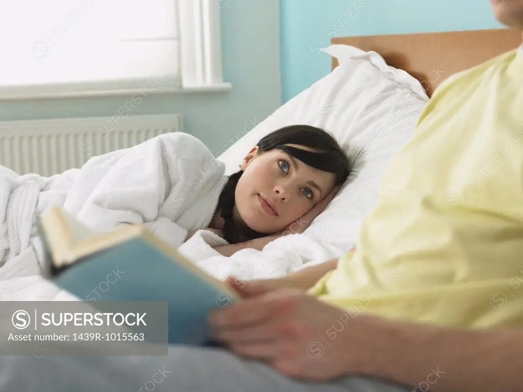 Young couple reading in bed