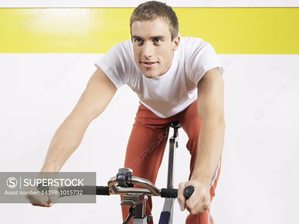 Man on exercise bike in health club