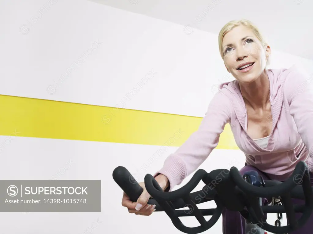 Woman on exercise bike in health club 