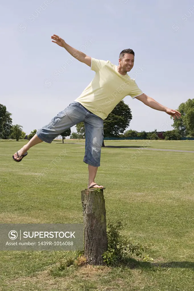 Man balancing on tree stump