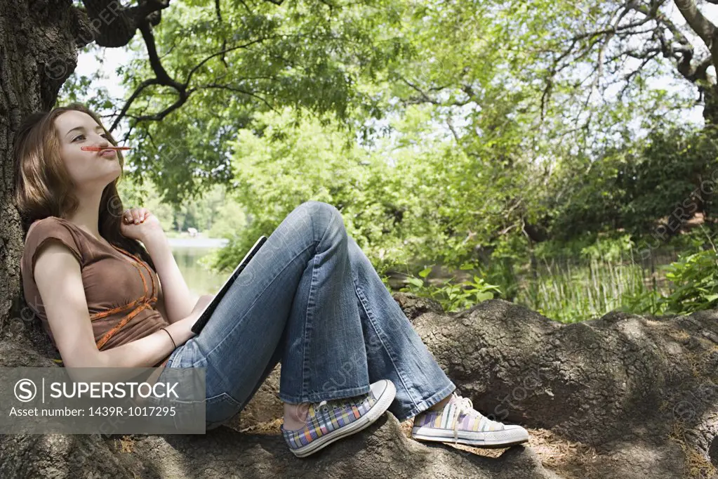 Girl sitting on a tree trunk