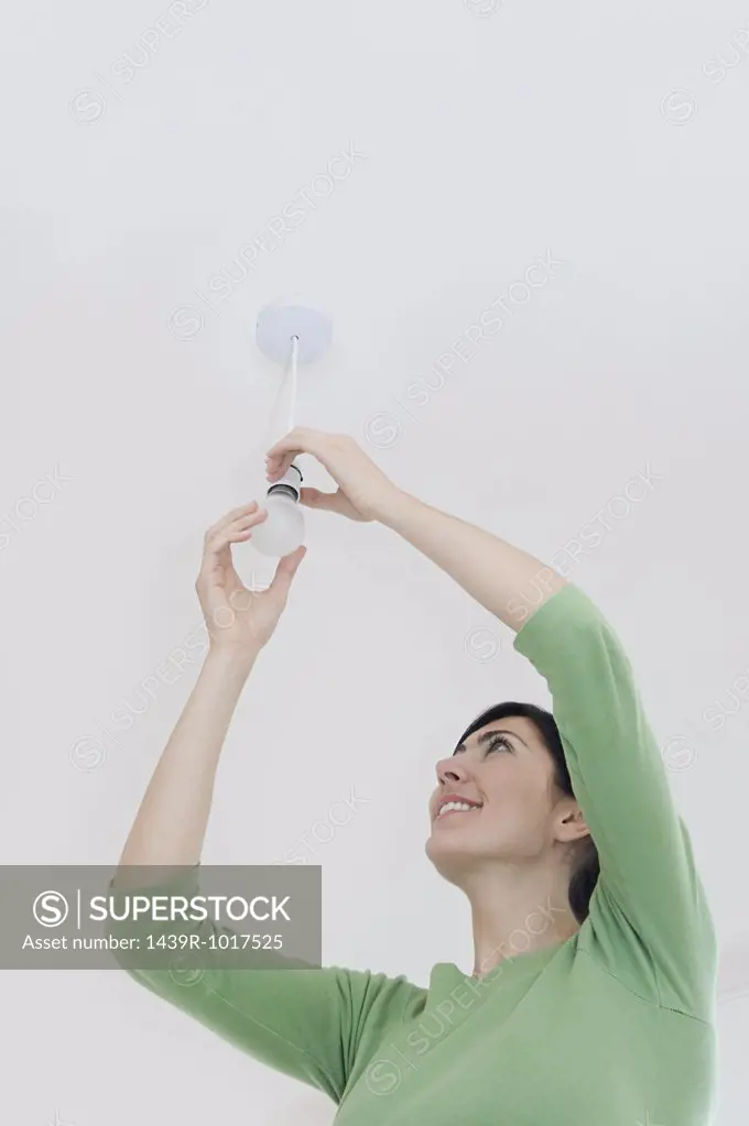Woman changing a lightbulb