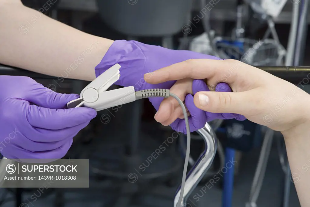 Surgeon putting finger clip on patient