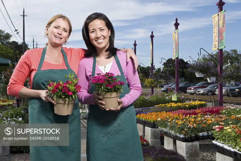 Two shop assistants holding flowers