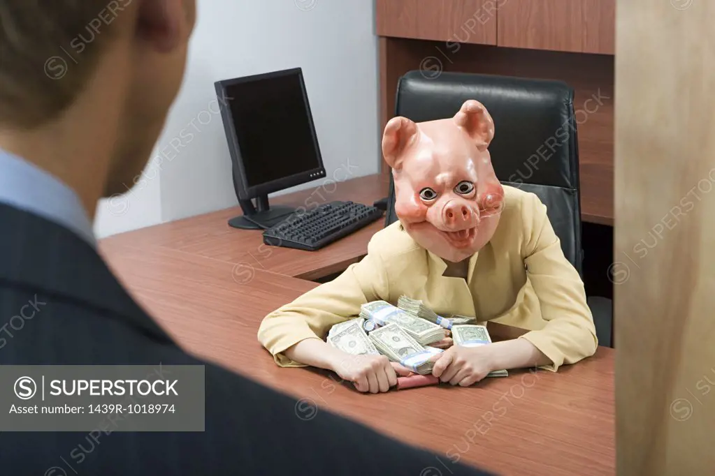Businesswoman in pig mask holding money