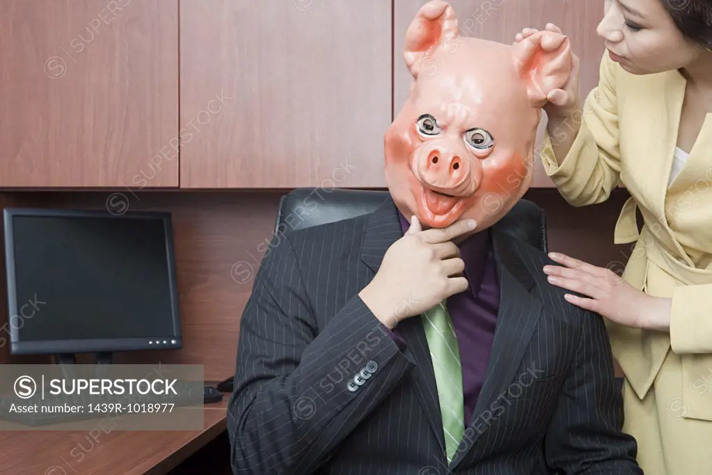 Businessman in pig mask and businesswoman