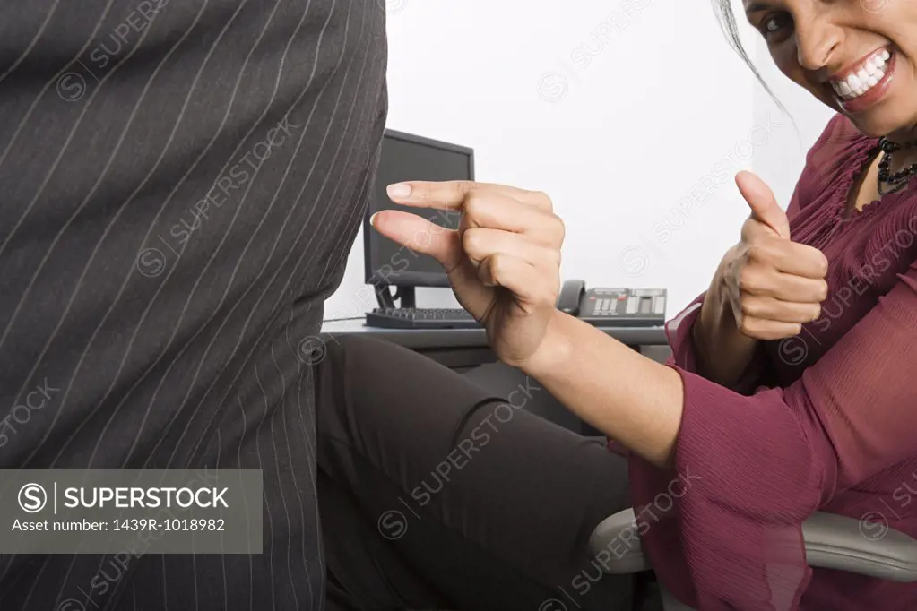 Businesswoman pinching colleagues buttock