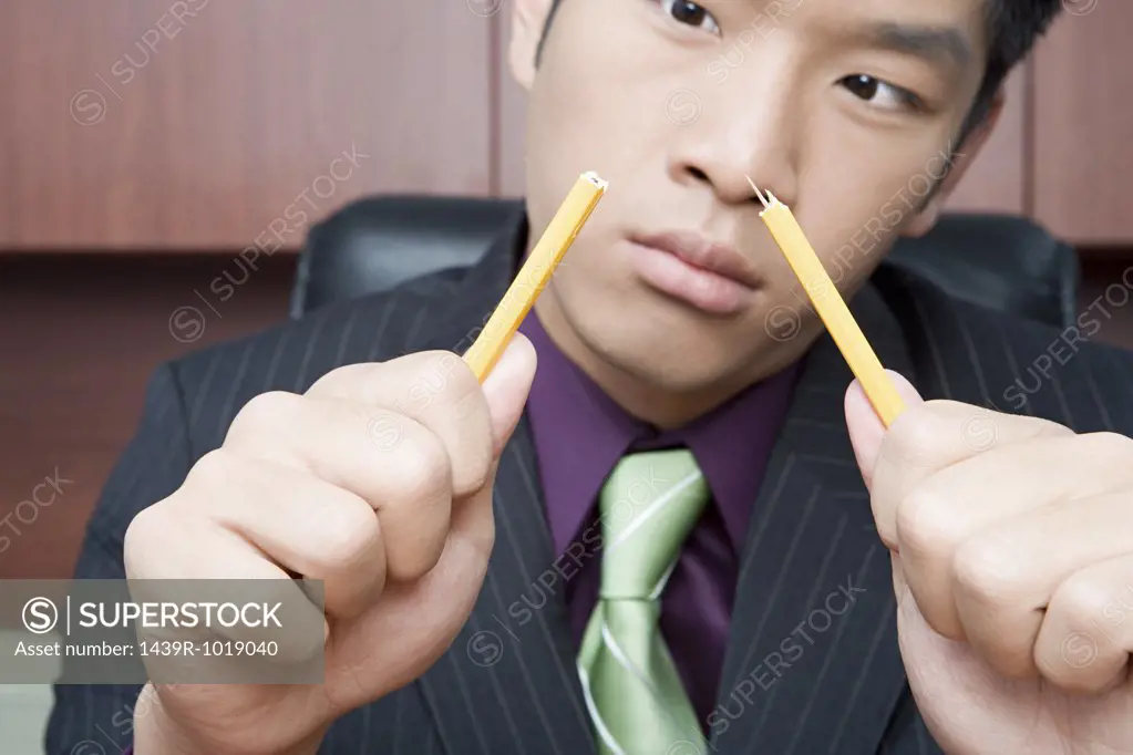 Businessman breaking pencil
