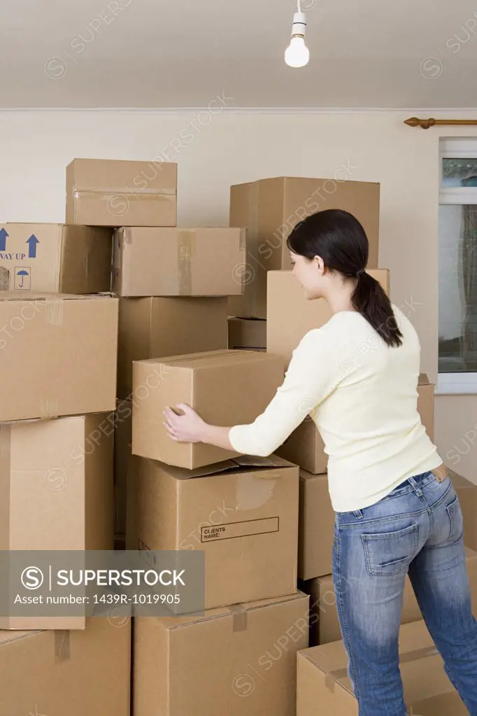 Woman stacking cardboard boxes