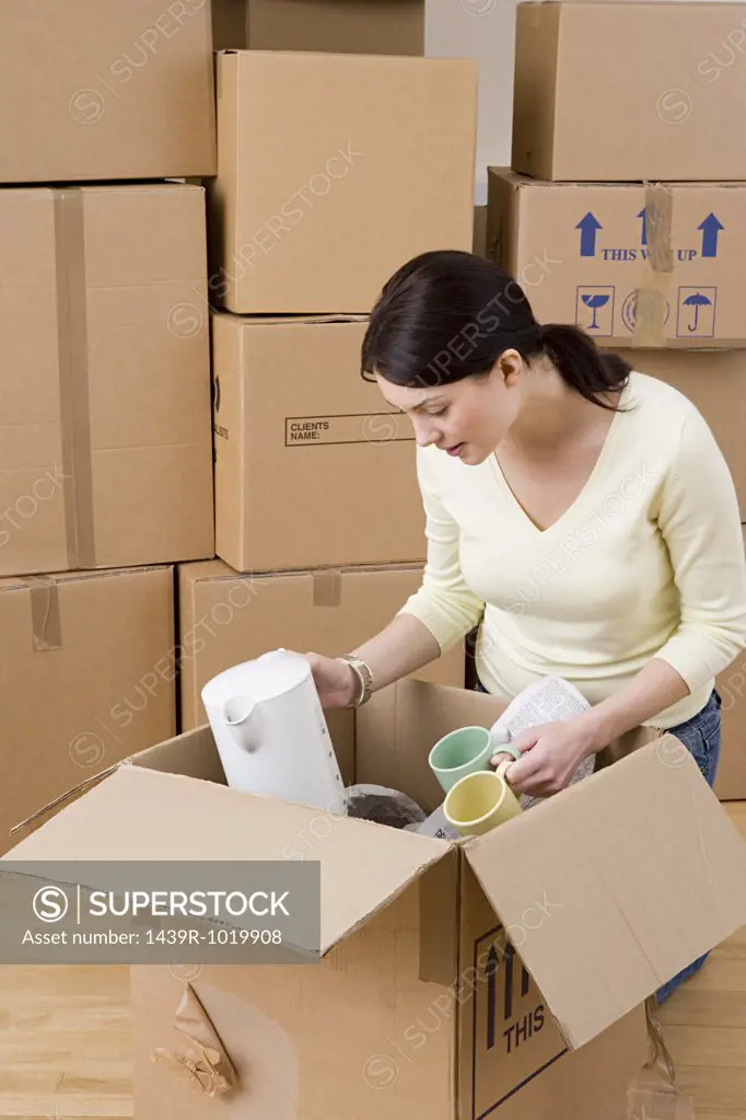 Woman unpacking cups and kettle