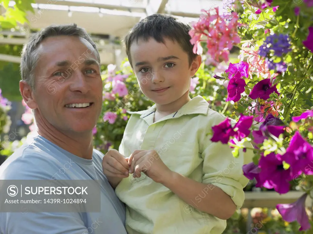 Father holding son in garden centre
