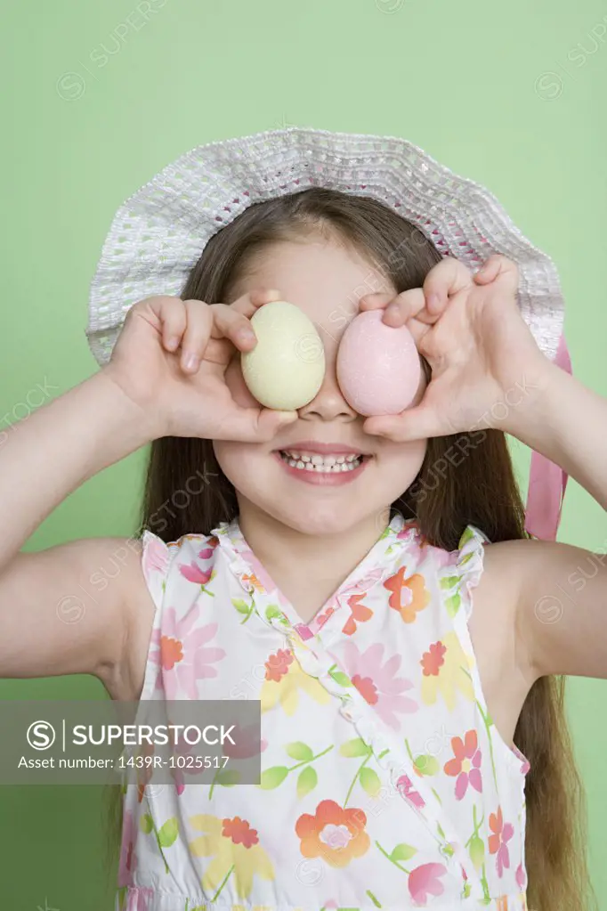 Girl holding easter eggs to eyes