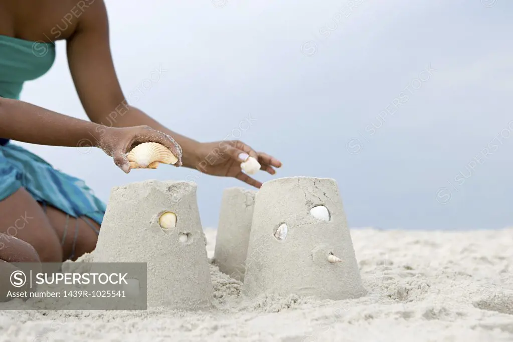 Mother and child putting shells on sandcastles